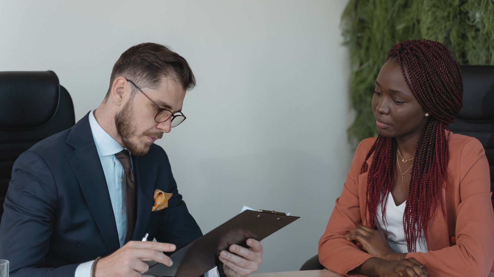 Candidate listening while an interviewer reviews notes.