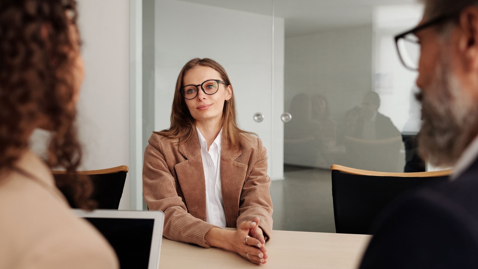 Job candidate speaking with interviewers across a table.